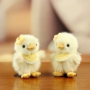 Tierno peluche de pollito amarillo esponjoso con babero de ganchillo y flor, colgante suave.