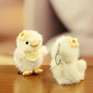 Detalle de llavero de peluche de patito tierno, colgante de bolso pollito amarillo suave.