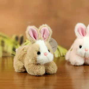 Close-up detail of cute plush rabbit toy keychain, soft fluffy bunny doll with metal ring.