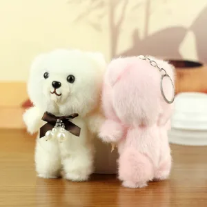 Plush bear keychain detail, cute stuffed animal bag charm with bow and pearl, soft toy pendant.