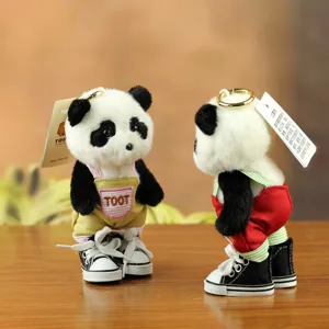 Detailed close-up of cute panda plush keychain wearing stylish overalls and sneakers.