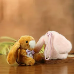 Detalle de llavero de conejo de peluche suave con lazo elegante y gancho resistente.