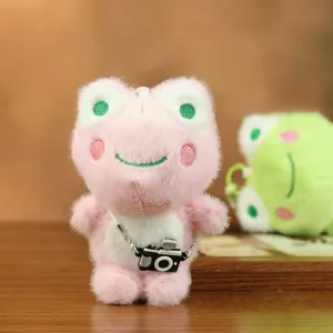 Detalle en primer plano del lindo colgante de peluche de rana rosa con minicámara y llavero.