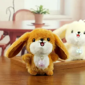 Cute plush rabbit toy detail showing soft brown fur and beaded necklace pendant in home setting.