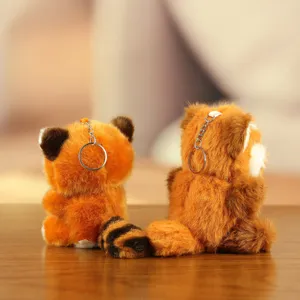 Cute red panda plush keychain detail view, soft fluffy material and metal ring pendant.