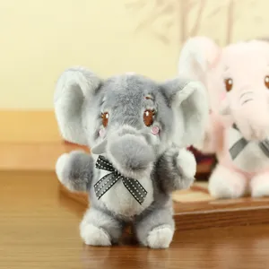 Detailed view of a cute grey plush elephant keychain with bow, soft stuffed toy charm.