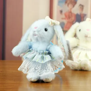 Blue bunny plush toy detail shot, featuring fluffy fur, floral lace dress and matching bow.