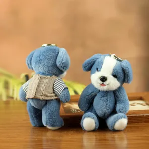Primer plano detallado del adorable llavero de perrito de peluche azul con chaleco.