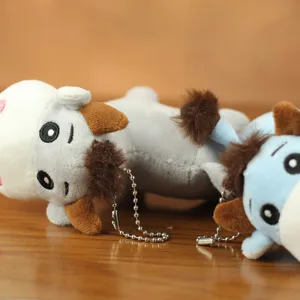Dettaglio portachiavi in peluche mucca, morbido materiale in peluche con piccola catena.