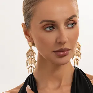 Nahaufnahme detailreicher goldfarbener Statement-Ohrringe mit mehrstufigem Design, eleganter Schmuck.