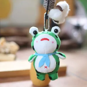 Lindo llavero de peluche de rana verde, suave muñeco de peluche con bufanda azul, vista detalle.