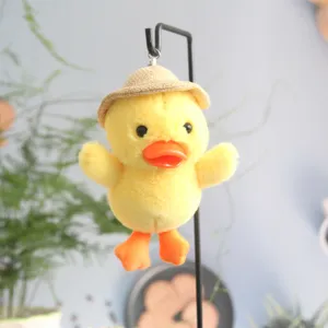 Primo piano dettagliato del ciondolo in peluche di paperella gialla con cappello di paglia.