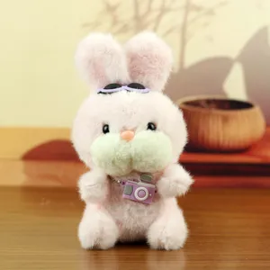 Gros plan détaillé d'un lapin en peluche rose avec des lunettes et un mini appareil photo jouet.