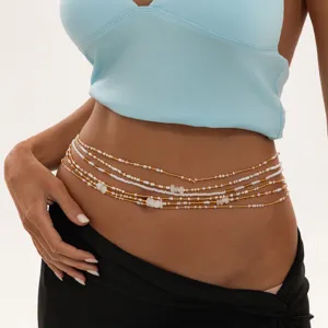 Gros plan détail chaîne taille multicouche boho perles, or blanc bijou corps plage.