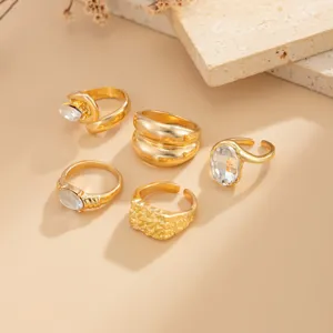 Detailed view of trendy gold ring set featuring irregular textures and sparkling crystal stones.