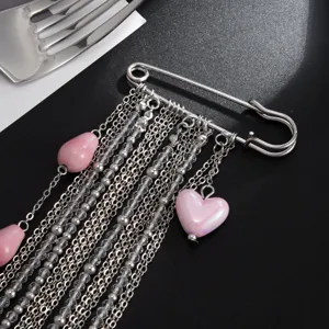 Vue de détail d'une élégante broche épingle avec des perles en céramique cœur rose.