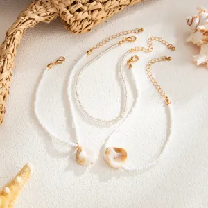 Fashion beach resort style shell pendant anklet set with white rice beads and golden chains.