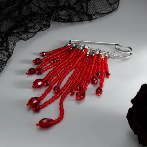 Vue détaillée d'une broche élégante en épingle de sûreté argentée ornée de franges de perles.