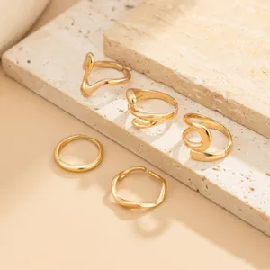 Detalle en primer plano de un conjunto de anillos geométricos dorados irregulares.