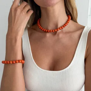 Detailaufnahme mit orangefarbenem Perlen-Halskette und Armband Set als Sommerschmuck.