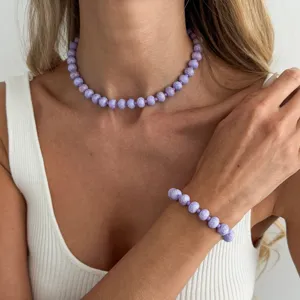 Nahaufnahme Detailansicht einer lila gesprenkelten Perlenkette und Armband Schmuckset.