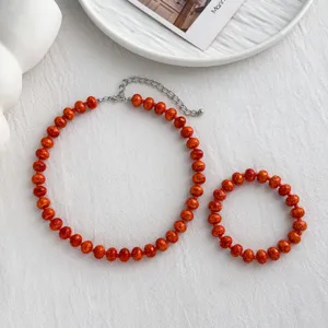 Orange gesprenkeltes Perlen Halskette und Armband Set, sommerlicher Freizeitschmuck für Damen.