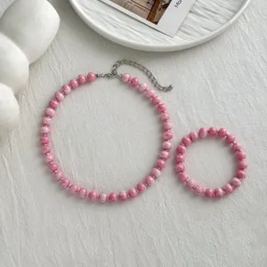 Rosa Perlenkette und Armband Set Detailansicht mit bunten strukturierten runden Perlen.