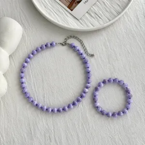 Detailansicht eines lila Perlenhalsketten- und Armbandsets mit silberner Verlängerungskette.