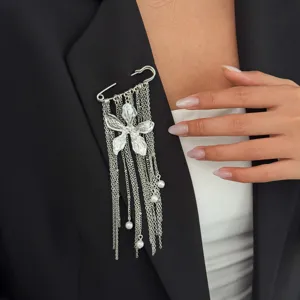 Chic silver safety pin brooch featuring a floral charm and delicate dangles for stylish wear.