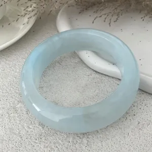 Dettaglio in primo piano del bracciale in resina azzurra con finitura liscia.