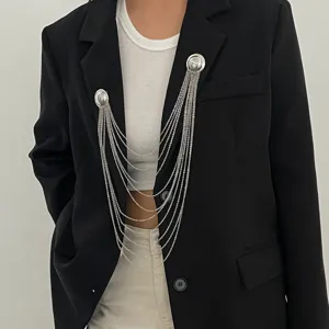 Vue rapprochée d'une broche à chaînes argentées multiples sur un blazer noir, accessoire.