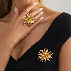 Detailed shot of gold irregular flower ring and brooch set, elegant party jewelry.