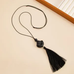 Black resin shell pendant long tassel necklace with adjustable wax cord, detail view.