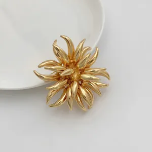 Close-up detail shot of a luxurious gold irregular flower brooch for elegant evening party