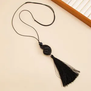 Black resin spiral pendant necklace with long tassel and adjustable wax rope sweater chain.