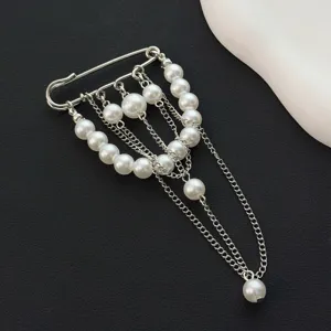 Detail view of silver-tone safety pin brooch with cascading faux pearls and delicate chains.