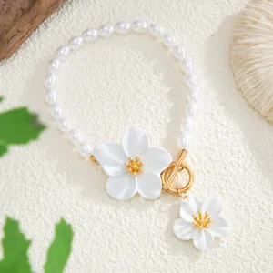 Detalle en primer plano de tobillera de perlas boho de playa con dije de flor pintada y cierre.