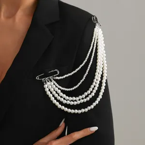 Detail shot of multi-layer pearl brooch, elegant pin chain design for women fashion apparel.