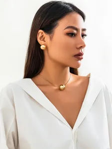 Minimalist gold snake bone chain sphere pendant necklace and earrings set for women detail view.
