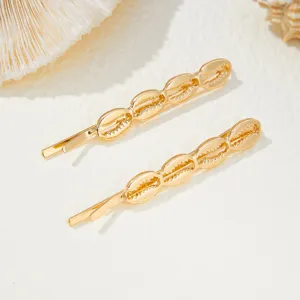 Detail view of golden shell hairpin, beach marine style fashion hair accessory for elegant looks.
