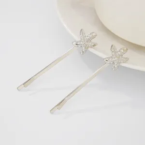 Close-up detail of silver starfish bobby pin hair clip, elegant ocean beach fashion accessory.