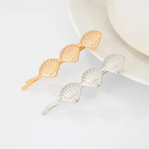 Gold and silver metal seashell hair clips, elegant beach style hair accessory detail view.