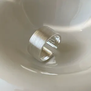 Exquisite matte wide open ring detail shot, minimalist silver geometric design for women's daily wear.
