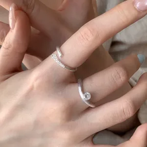 Close-up detail of stylish silver open rings featuring cubic zirconia and delicate textured bands.