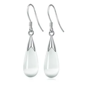 Detail view of elegant white teardrop dangle earrings with silver hook, minimalist aesthetic piece.