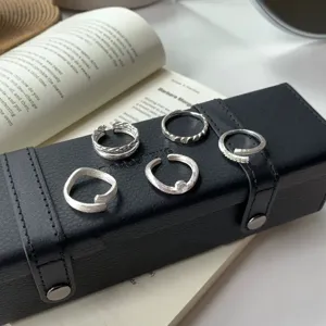 Detailed shot of multi-style silver open rings set, elegant minimalist jewelry design.