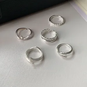 Detailed view of 5 minimalist open rings with unique textures and diamond accents for daily wear.