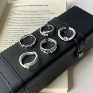 Set of five unique silver open rings featuring modern niche minimalist designs on black box.