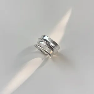 Detailweergave van minimalistische geometrische matte zilveren ring met prachtig gelaagd ontwerp.