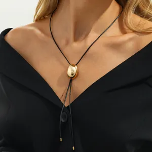 Gold oval pendant black cord necklace detailed close-up view showcasing modern style.